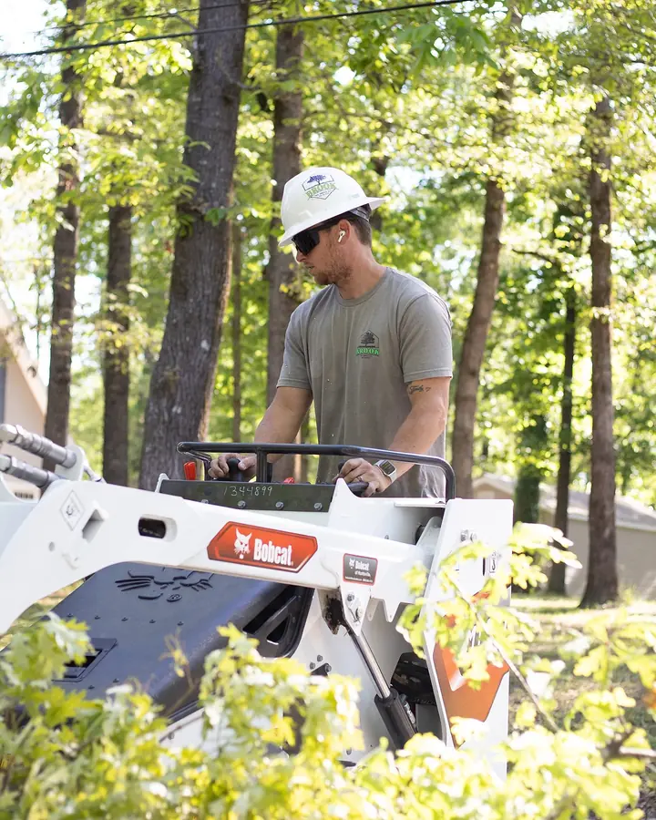 Crew operating Bobcat equipment for debris removal and cleanup