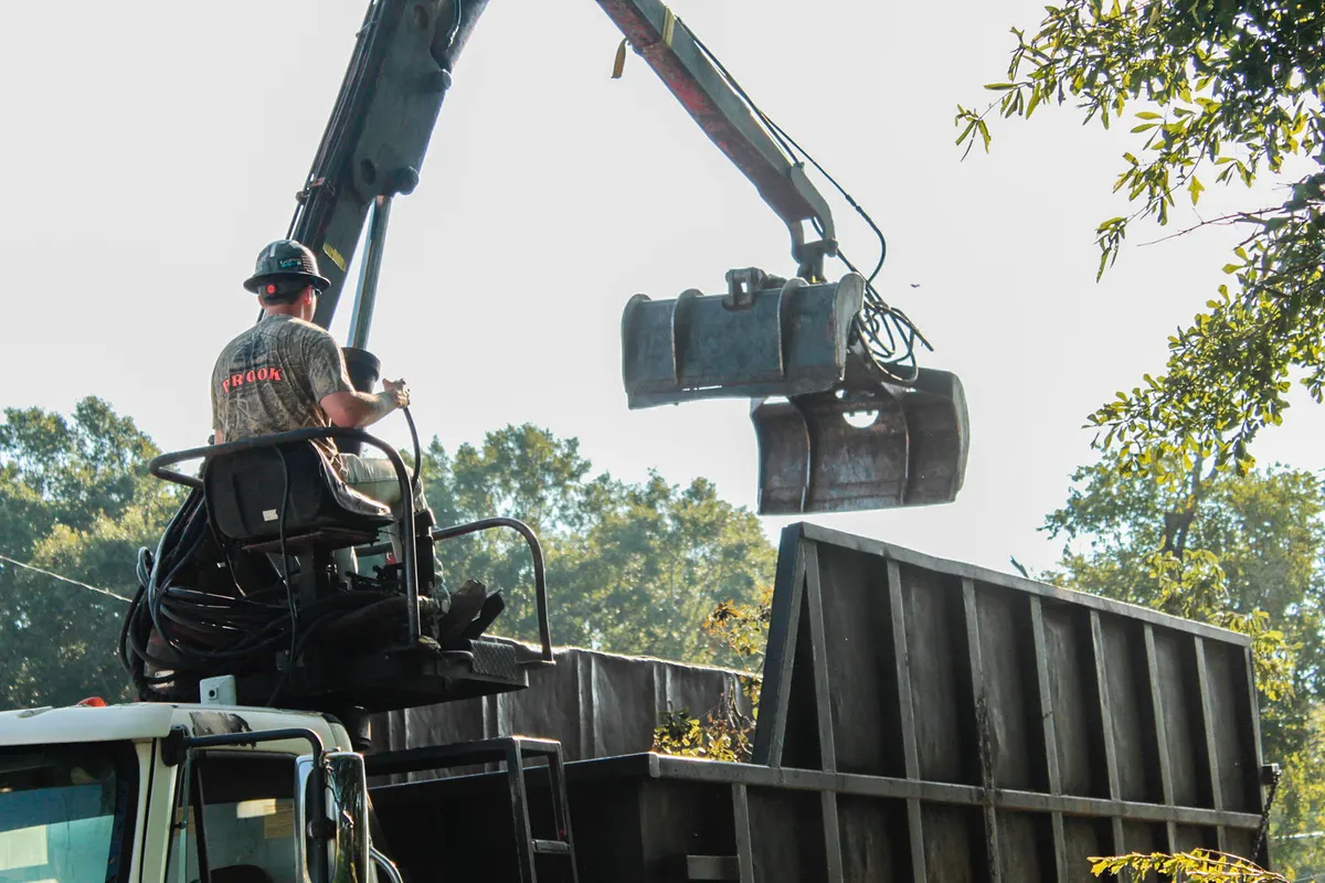 Grapple truck lifting a large log section for haul-off